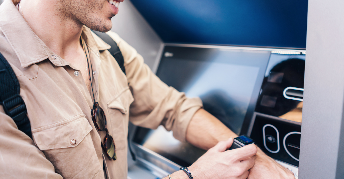 Homme utilisant un distributeur automatique de billets avec une montre-bracelet