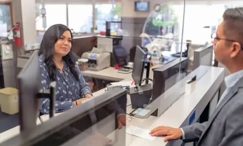 Un caissier de banque aide un homme au guichet à copier