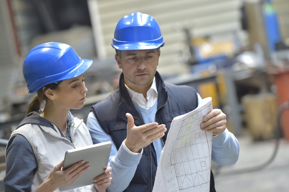 Ingénieurs dans une usine mécanique lisant des instructions