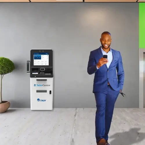Homme en costume bleu s'éloignant d'un distributeur automatique de billets TellerCentral 
