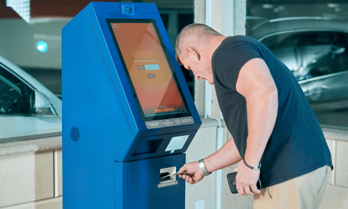 Homme utilisant un guichet automatique bancaire bleu Copie