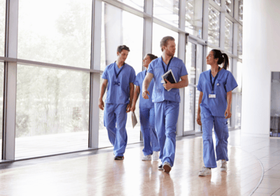 Un groupe de médecins marchant avec assurance dans un couloir bien éclairé