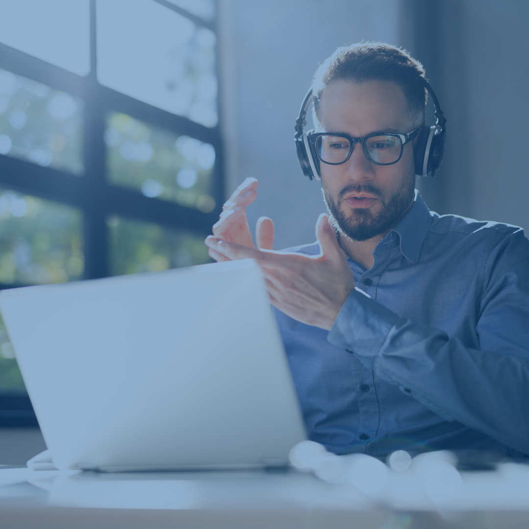 Homme avec des écouteurs tapant des mains tout en regardant un webinaire sur un ordinateur portable