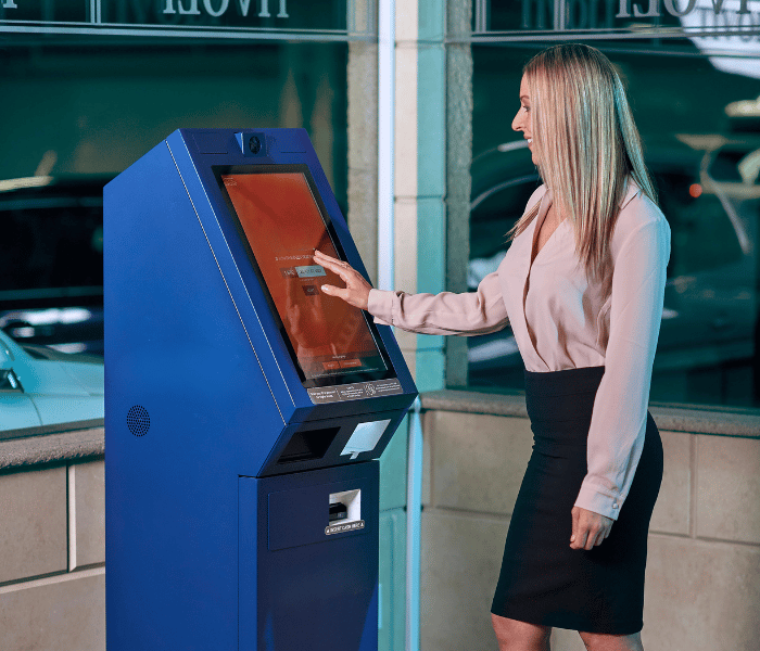 Femme utilisant un automate de nouvelle génération dans une banque.