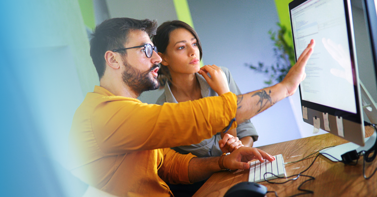 Homme montrant à une femme comment utiliser un logiciel 