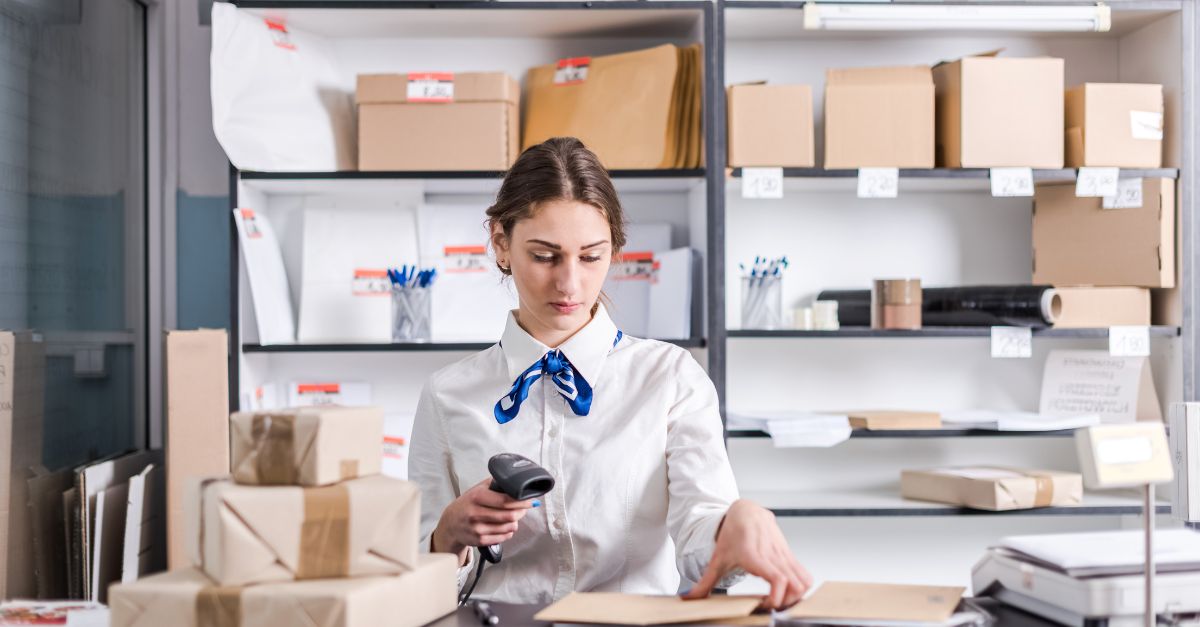 Une femme scanne des boîtes au bureau de poste