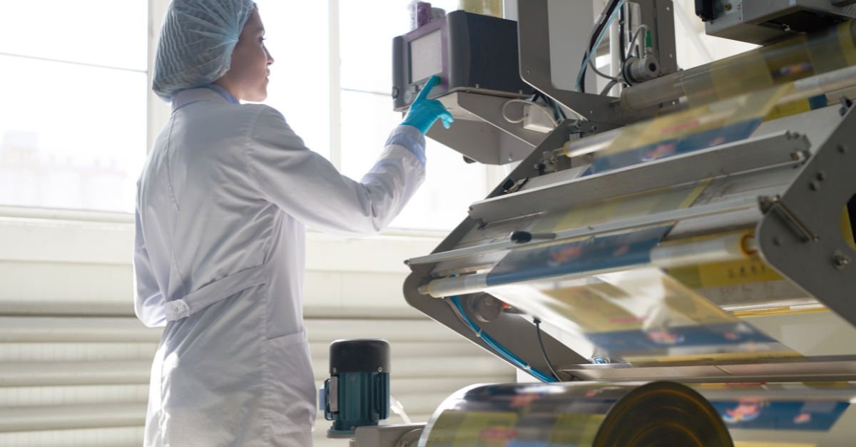 Femme portant une blouse de laboratoire et utilisant une machine d'impression à l'encre industrielle 