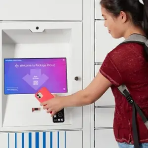 Un élève utilise son téléphone dans le casier des colis intelligents Un élève utilise son téléphone dans le casier des colis intelligents